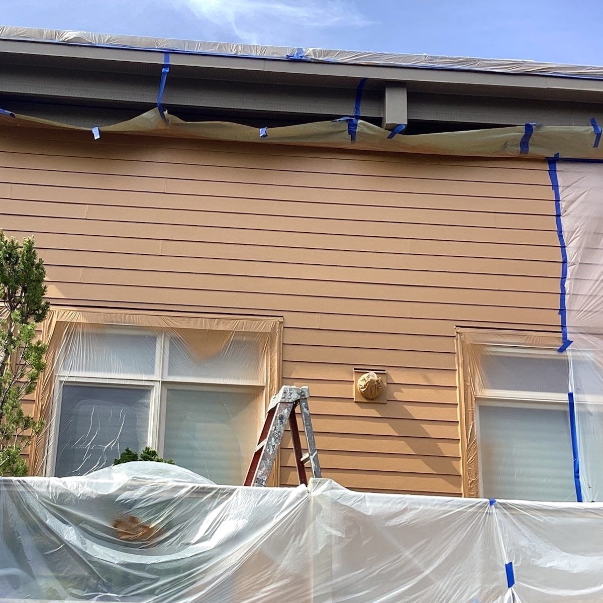 Exterior House Painting Project Underway, Complete With Painters Tape, Drip Cloths, Ladder